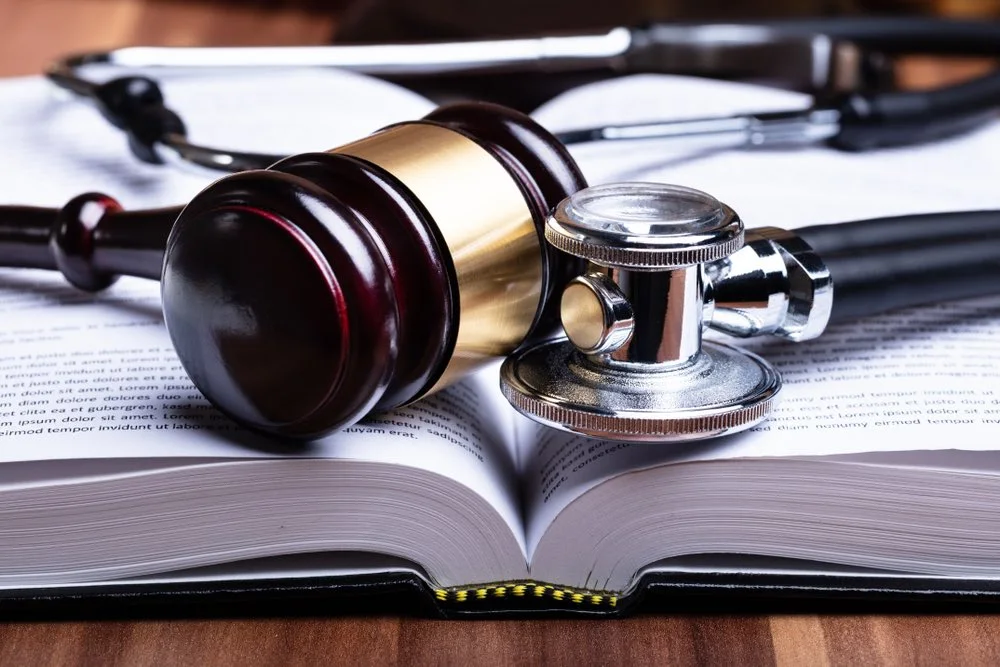 Gavel, stethoscope, and law book arranged together, representing the legal and medical aspects of understanding a birth injury lawsuit.