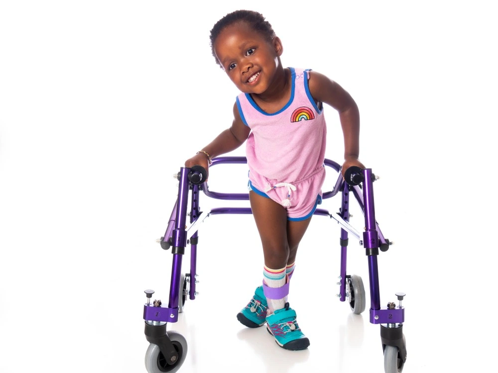 Child participating in physical therapy using an assistive device, illustrating the goals of cerebral palsy treatment and ongoing care.