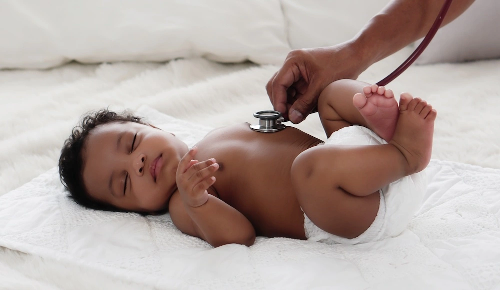 Newborn baby being examined by a doctor, illustrating what fetal distress is and how it may affect infants at birth.