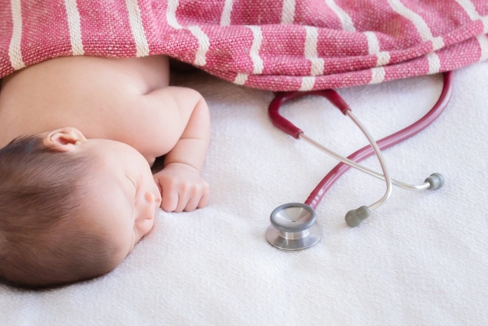Newborn baby with a stethoscope nearby, illustrating what forceps deliveries are and their role during childbirth.