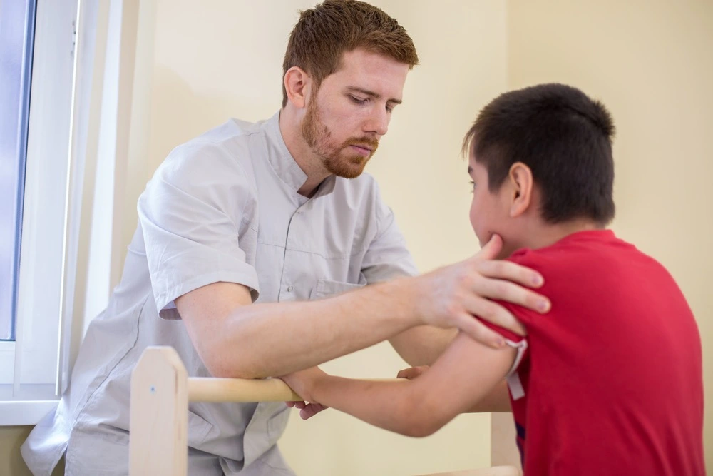 Child undergoing physical therapy with a medical professional, illustrating non-economic damages and compensation in birth injury cases.